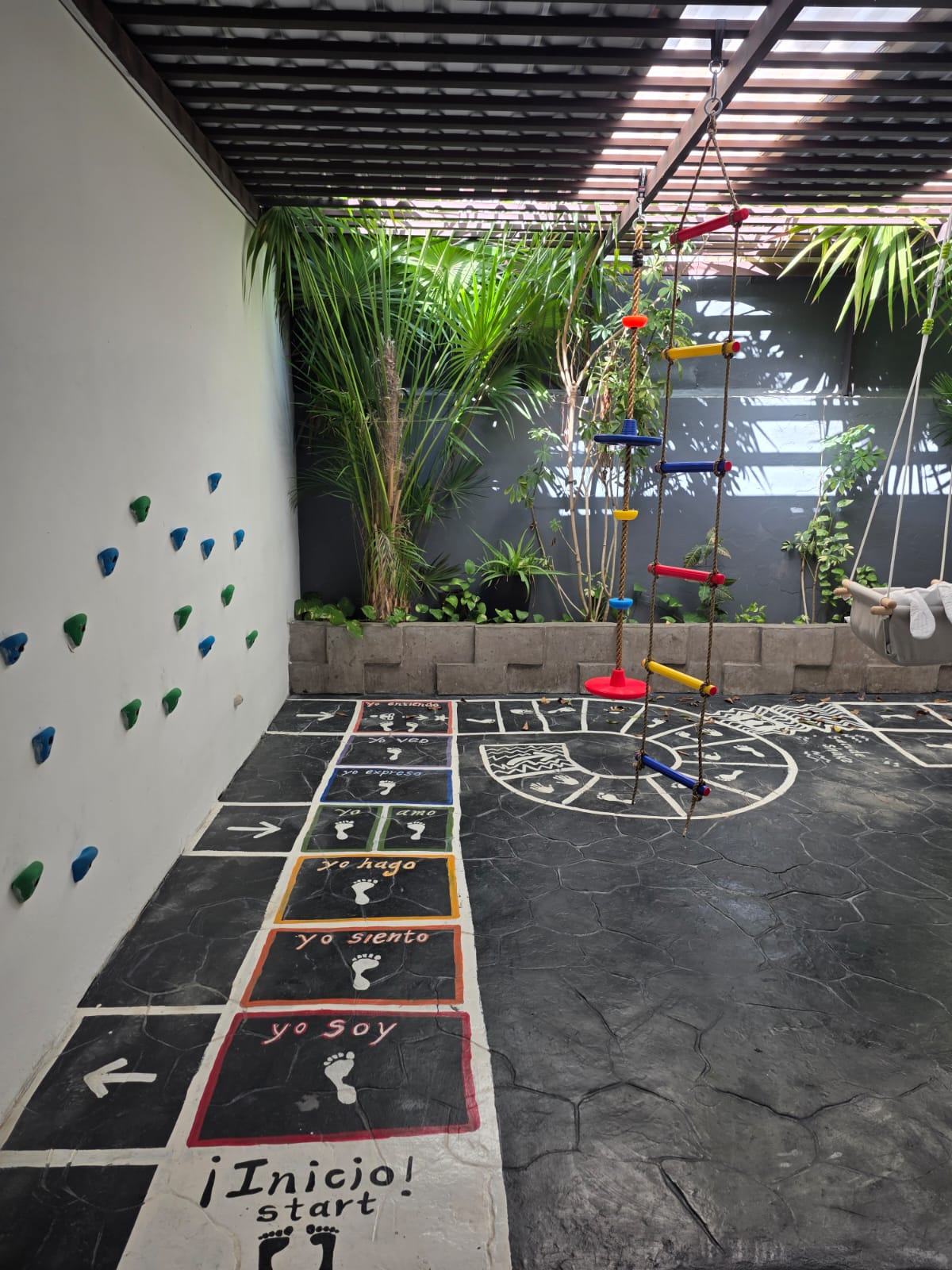 Patio sensorial con muro de escalada y juegos al aire libre en Nenelandia